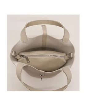 Binnenaanzicht van beige leren emmer tas met uitneembare binnentas en zilverkleurige hardware