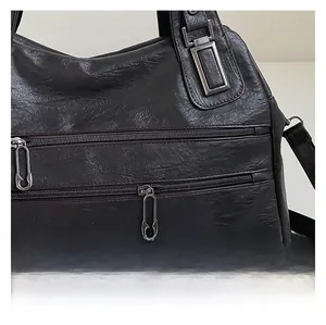 Close-up of vintage pleated coffee PU leather bag featuring unique safety pin zippers