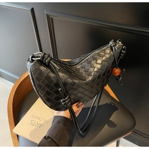 Detail of woven leather tote with knot strap, amber bead and high-quality metal zipper