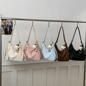 Detail showing five colors of leather tote bags with cute plush charms and straps
