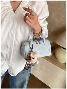 Dettaglio della borsa Boston azzurra con zip argento e ciondolo orsetto in denim