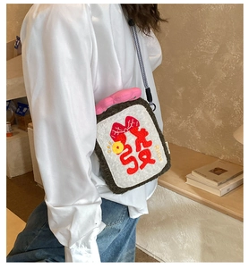 Detail of cute plush crossbody bag with rich embroidery shown on model for daily styling