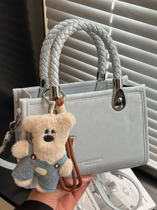 Chic light blue square crossbody bag with woven handles and a cute bear pendant