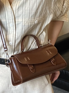 Elegant brown leather crossbody bag with top handle and glossy finish in retro style