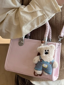 Pink square crossbody bag with woven handle and cute plush bear charm decoration
