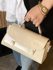Minimalist beige structured top-handle crossbody bag with elegant flap design and round clasps