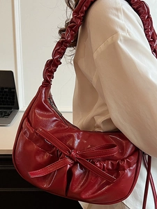 Fashionable dark red pleated shoulder bag with a bow accent and crescent moon shape