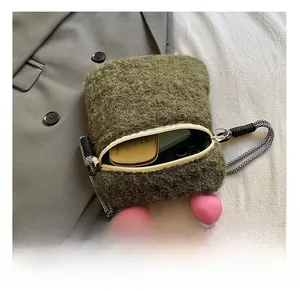 Detail view of moss green plush crossbody bag showing inner space for phone and makeup