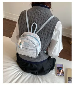 Detail of a mini light blue patchwork backpack with Nordic pattern and plush bear charm