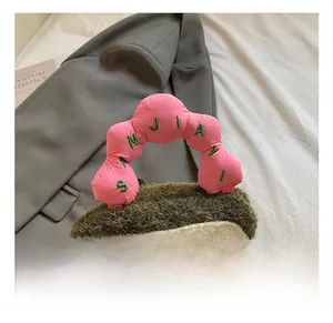 Detailed view of plush handbag with pink padded handle and green sherpa fabric