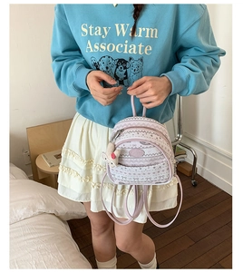 Detail of mini backpack with wavy patterns and cute white rabbit plush charm