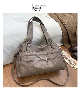 Detail of camel faux leather bag showing metal zippers and textured surface on blazer