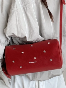 Red cylindrical shoulder bag with silver star rivets and crossbody strap for women