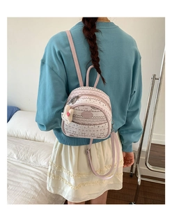 Close-up of mini backpack with wave pattern and cute plush bunny charm on the strap