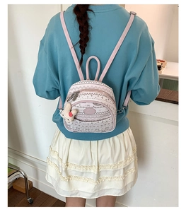 Detail showing back view of mini backpack with cute bunny charm and bow pattern
