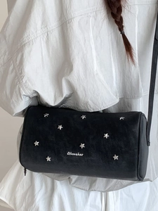 Chic black cylinder crossbody bag with silver star rivets and matte leather finish