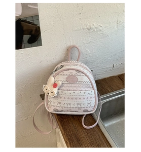 Detailed view of the pink jacquard mini backpack with cute pattern and rabbit pendant