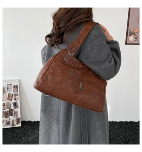 Detail showing side view of brown vintage tote bag with twin parallel zip pockets