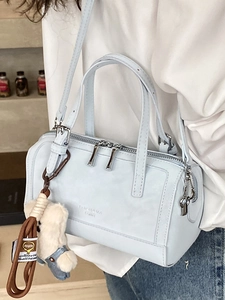 Borsa a tracolla azzurra modello pillow con ciondolo a orsetto indossata da modella