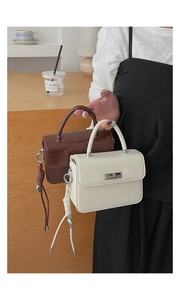 Detailansicht kleiner Retro-Handtaschen mit Metalldrehverschluss und Flechtanhänger