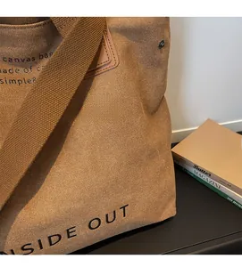 Detail of coffee brown canvas tote bag featuring texture and side out text design