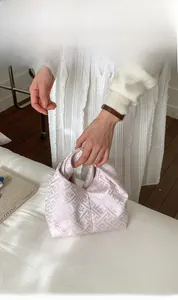 Détail d'un sac vintage avec broderie violet clair et texture de tissu soyeux de luxe