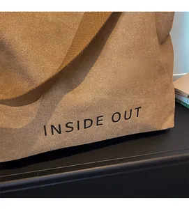 Close-up of canvas tote bag showing side texture and black INSIDE OUT lettering detail