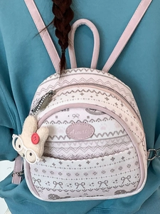 Pink and white patterned backpack with cute rabbit charm shown on a casual cyan hoodie