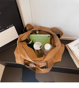 Top view showing a large capacity brown canvas tote bag holding a tablet and daily essentials