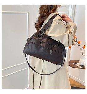 Detail of vintage coffee brown Boston bag showing leather texture and zipper pockets