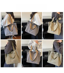 Detail view of large canvas tote bag with adjustable shoulder straps and inside out text