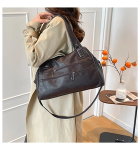 Detail view of brown vintage leather tote bag with double front zippers and wide strap