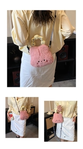 Detail of cute pink plush cartoon crossbody bag with embroidered face and lettered handle