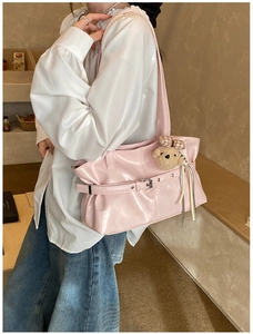 Détail du sac sous le bras en cuir PU rose brillant avec un joli petit ours en peluche