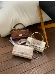Detailansicht der Handtaschen mit Krokodilprägung und eleganten Metalldrehverschlüssen