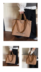 Detail of a large brown canvas tote bag with artistic lettering for daily commute