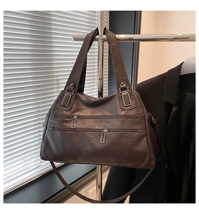 Detail of dark brown vintage faux leather bag with unique safety pin zipper pullers
