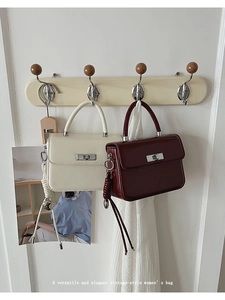 Detailansicht der cremefarbenen und burgunderroten Vintage-Lackledertaschen mit Metallschloss