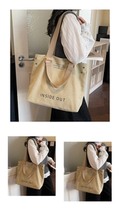 Detail of khaki canvas tote bag with INSIDE OUT print and metal rivet accents