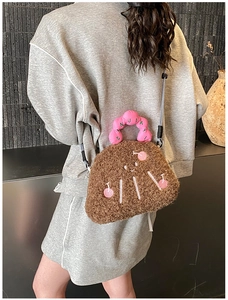 Close-up of cute brown plush crossbody bag with pink handle and polka dot strap shown on model