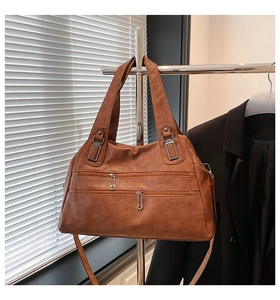 Detail of vintage brown leather bag with dual zipper layers and silver metallic hardware