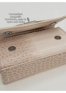 Detail der cremefarbenen Krokoprägung-Tasche mit silbernem Doppel-Magnetverschluss