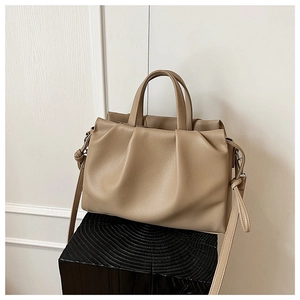 Dettaglio ravvicinato di borsa kaki a pieghe in pelle con elegante trama a grana litchi