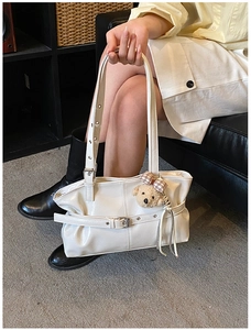 Détail du cabas en cuir PU blanc avec boucle croisée et breloque ourson marron mignon
