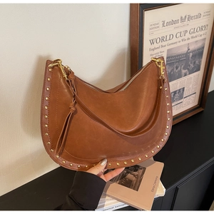 Detail showing brown leather texture and golden rivet studs on the stylish crossbody bag