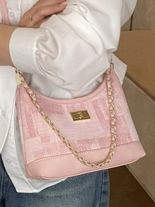 Pink tweed crossbody bag with gold chain and leather trim shown on a model outfit