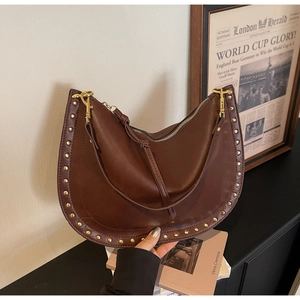 Detailed macro view of vintage brown leather bag with golden studs and metal zipper