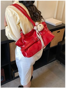 Sac bandoulière en cuir verni rouge avec boucle argentée et charm ours à carreaux