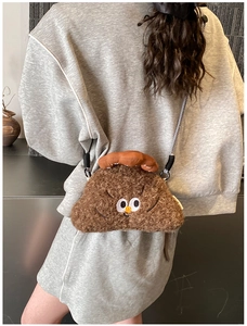 Brown plush cartoon crossbody bag with eyes, shown on person for size perspective