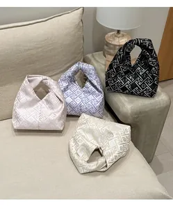 Vue détaillée de quatre sacs à nœuds en soie avec broderie florale et reflets métalliques